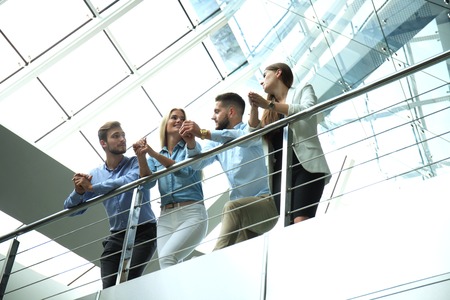 Bottom view. Modern people in casual wear having a brainstorm meeting while standing in the creative...