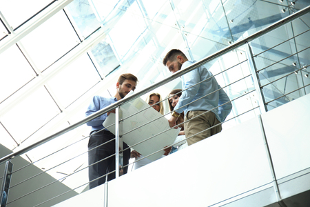 Bottom view. Modern people in casual wear having a brainstorm meeting while standing in the creative office.の写真素材