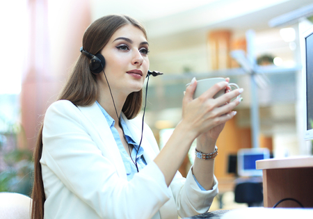 Woman customer support operator with headset and smiling.の写真素材