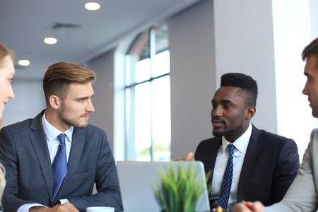 Business people in discussing something while sitting together at the table.の写真素材