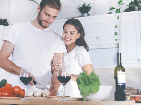 Beautiful young couple preparing a healthy meal together while spending free time at home.の写真素材