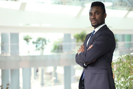 Successful African American businessman businessman standing in office.の写真素材