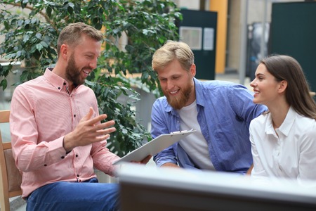 Young colleagues in smart casual wear working while spending time in the office.