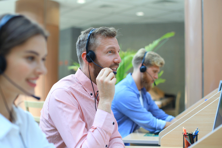 Attractive positive young businesspeople and colleagues in a call center office.