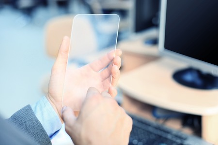 Close up of male hand with transparent smartphone.の写真素材