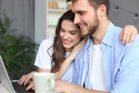 Couple pointing while working together on laptopの写真素材