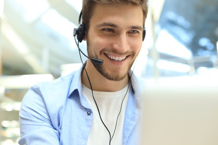 Happy young male customer support executive working in officeの写真素材