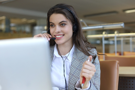 Female customer support operator with headset and smilingの写真素材