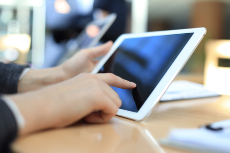 Image of human hand pointing at touchscreen in working environment at meetingの写真素材