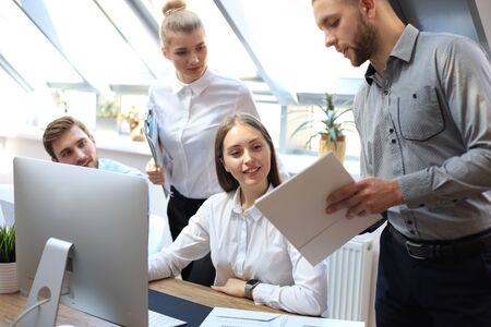 startup business team on meeting in modern bright office interior brainstorming, working on tablet...