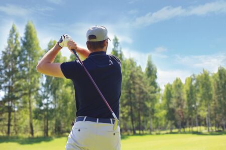 Golfer hits an fairway shot towards the club houseの写真素材