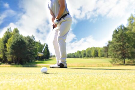 Golf approach shot with iron from fairway at sunny dayの写真素材