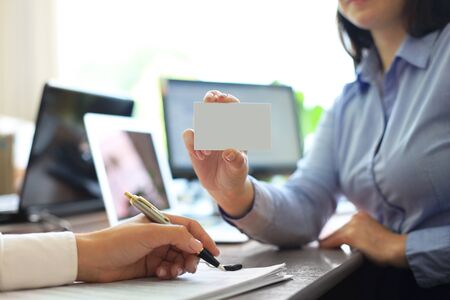 Business woman handing a blank business card