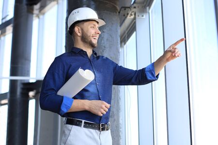 Shot of male architect wearing hardhat and inspecting new building