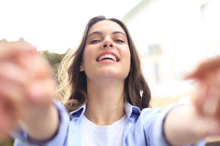 Beautiful woman is saying or talking to her boyfriend that give me your hands or pulling me please with smiley face.の写真素材