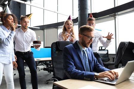 Business team celebrating a birthday of collegue in the modern office