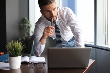 Elegant modern businessman analyzing data while working in office