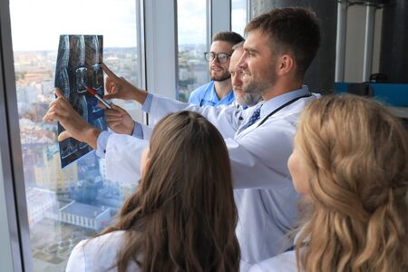 Group of doctors checking x-rays in a hospitalの写真素材