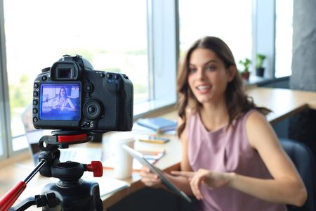 Beautiful young woman talking and smiling while making new video for her blogの写真素材