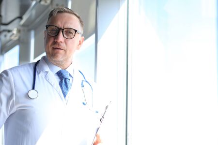 Senior chief physician in white robe with stethoscopeの写真素材