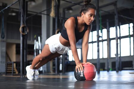 Fit and muscular woman exercising with medicine ball at gymの写真素材