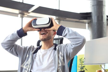 Young man playing game using virtual reality headset in the playing clubの写真素材