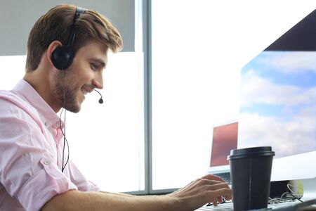 Smiling friendly handsome young male call centre operatorの写真素材