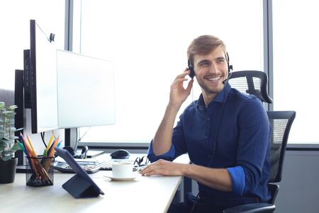 Happy young male customer support executive working in office