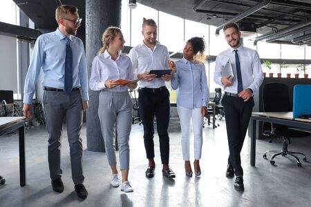 Modern business people have a discussion while walking through the office.の写真素材