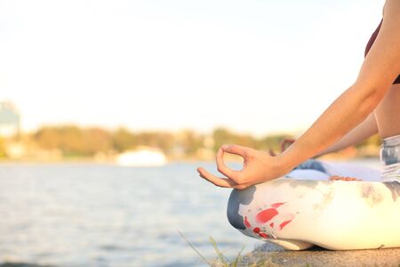 Close up hands of woman do yoga outdoor, lotus pose. Healthy and yoga conceptの写真素材