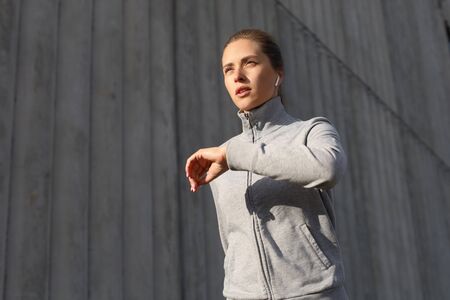 Young attractive sporty fitness woman running while exercising outdoors at sunset or sunrise in...
