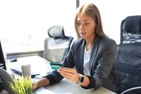 Woman holding credit card on laptop for online shopping conceptの写真素材