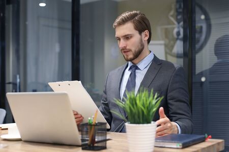 Portrait of young man sitting at his desk in the office
