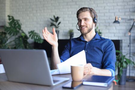 Concentrated young freelancer businessman using laptop for video conferance, working remotely online...