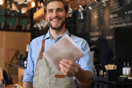 Smiling worker prepares orders at the bakeryの写真素材