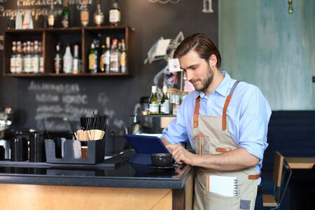 Small business owner working at his cafeの写真素材