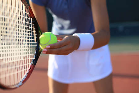 Close up of a tennis player hitting the ball with racketの写真素材