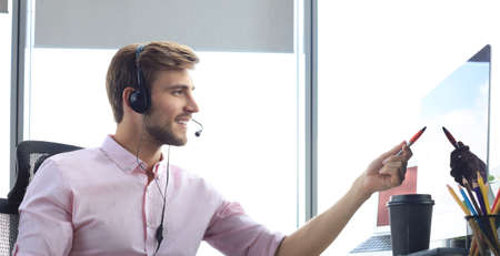 Happy young male customer support executive working in office