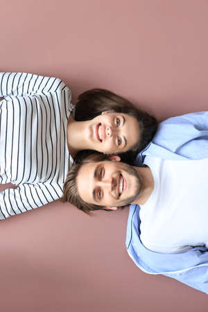Top view portrait of smiling young couple lying relaxing on warm floor at home, happy family relaxing at homeの写真素材