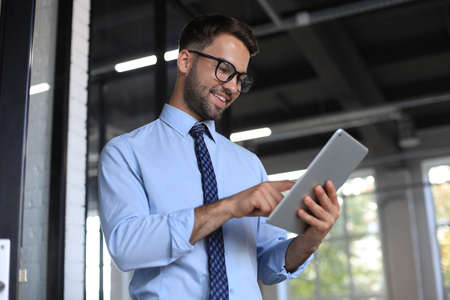 Young businessman using his tablet in the office