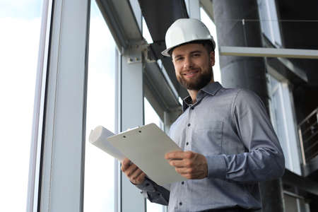 Shot of male architect wearing hardhat and inspecting new building