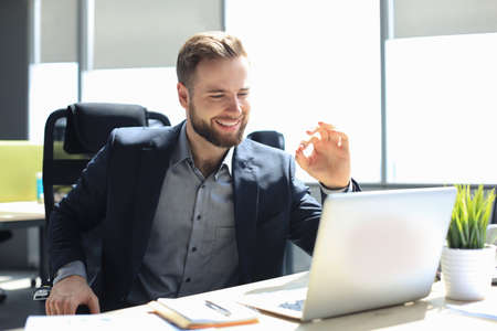 Smiling young business man having video call in officeの写真素材