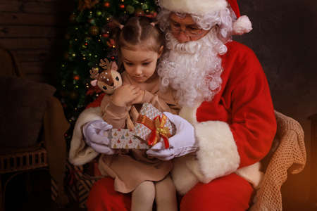 Santa Claus and child at home. Christmas gift. Family holiday conceptの写真素材
