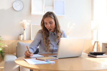 Freelance operator talking with headsets and consulting clients from home office