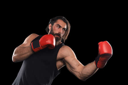 Kickboxer man fighting against black background. Sport concept