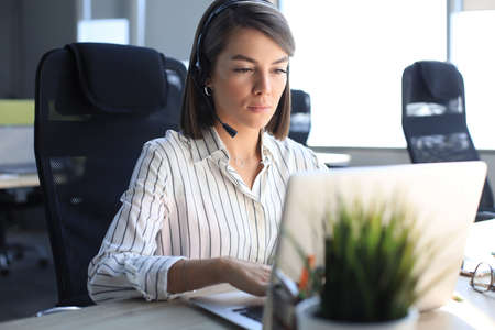 Female customer support operator with headset and smilingの写真素材