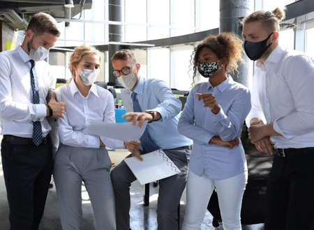 Business team in protective masks works in the office.