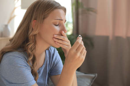 Sad woman sitting on a sofa in the living room