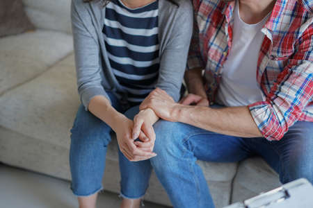 Young couple talking about their problem with psychologist in officeの写真素材
