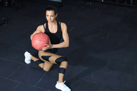 Fit and muscular woman exercising with medicine ball at gymの写真素材